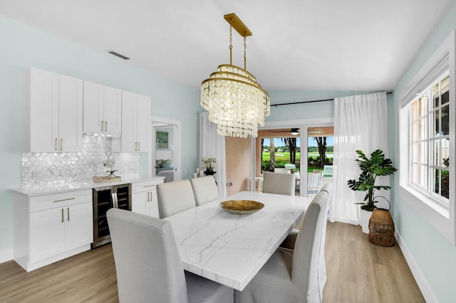 889 SW Balmoral Trce, Stuart, FL 34997 - dining room with beverage cooler, light wood-style floors, a chandelier, and baseboards