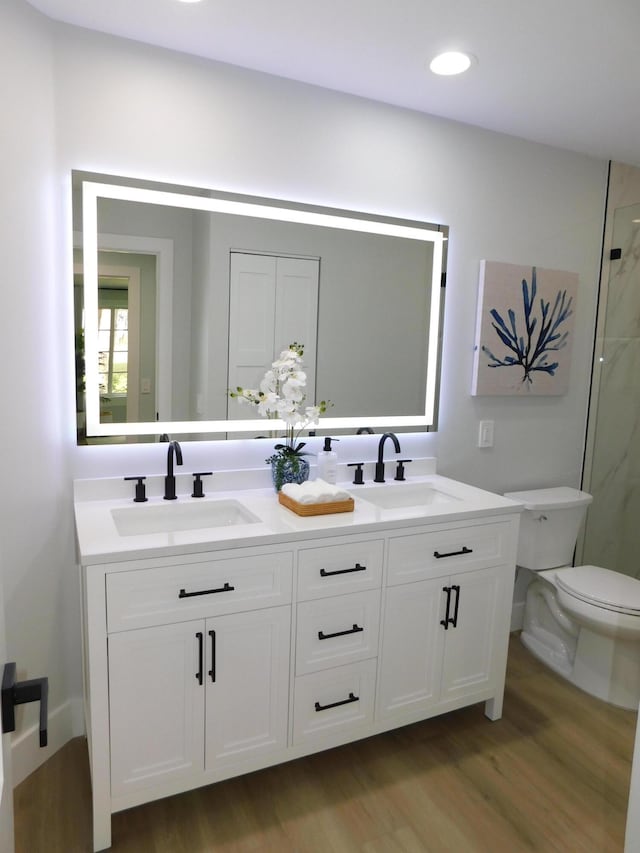 889 SW Balmoral Trce, Stuart, FL 34997 - full bathroom with wood finished floors, double vanity, toilet, a shower, and recessed lighting