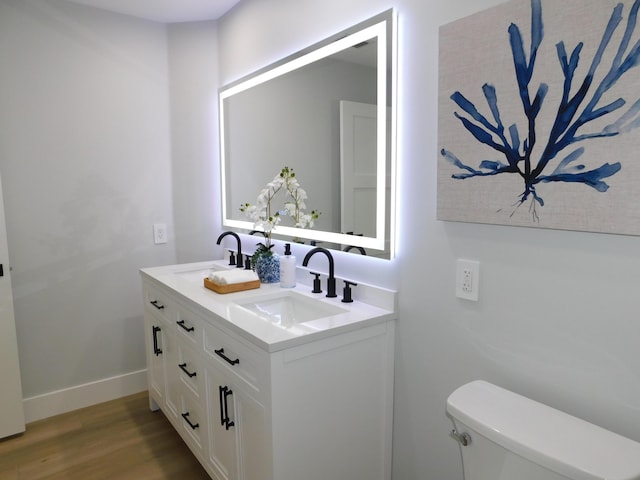 889 SW Balmoral Trce, Stuart, FL 34997 - bathroom with wood finished floors, double vanity, toilet, and baseboards