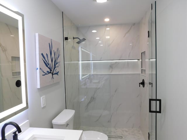 889 SW Balmoral Trce, Stuart, FL 34997 - bathroom with toilet, a marble finish shower, vanity, and recessed lighting