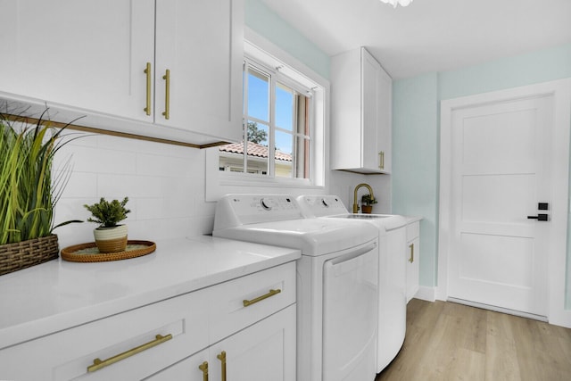 889 SW Balmoral Trce, Stuart, FL 34997 - laundry room featuring cabinet space, independent washer and dryer, and light wood-style flooring