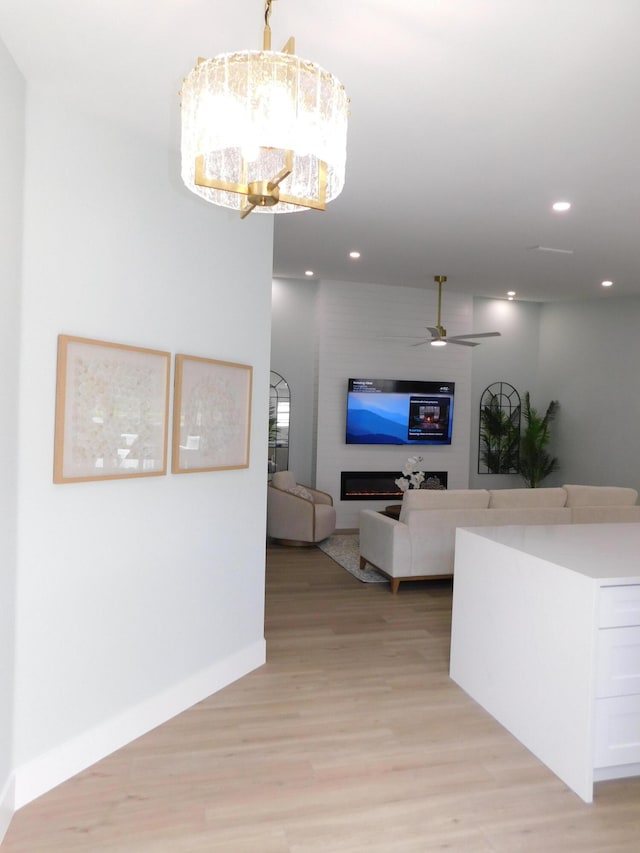 889 SW Balmoral Trce, Stuart, FL 34997 - living area with light wood finished floors, a ceiling fan, recessed lighting, a chandelier, and baseboards