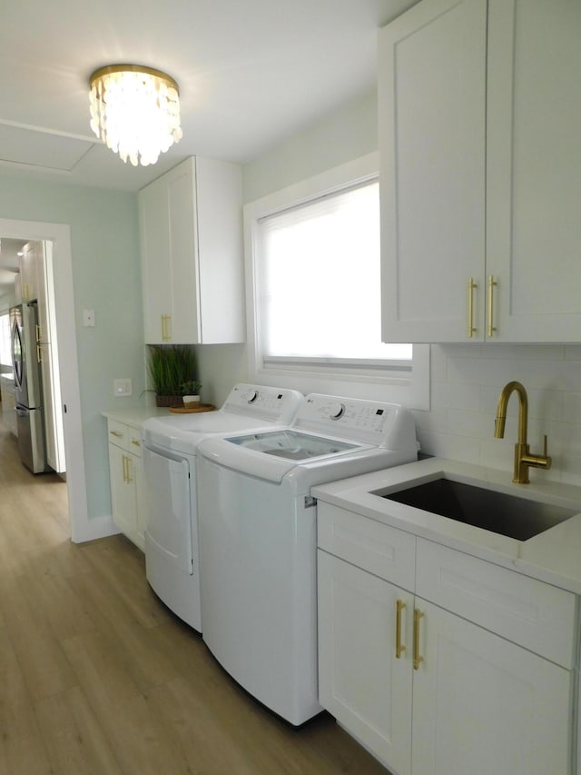 889 SW Balmoral Trce, Stuart, FL 34997 - laundry area featuring separate washer and dryer, cabinet space, and light wood-style flooring