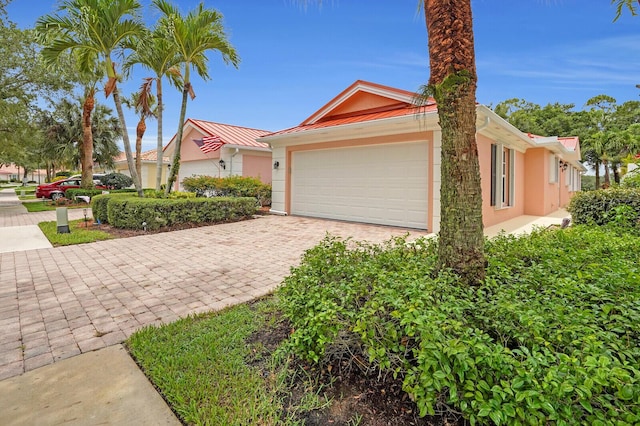 889 SW Balmoral Trce, Stuart, FL 34997 - view of front of property featuring stucco siding, a garage, a standing seam roof, and decorative driveway