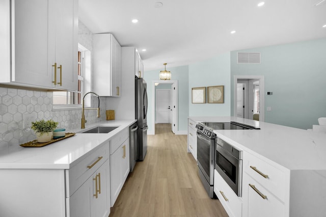 889 SW Balmoral Trce, Stuart, FL 34997 - kitchen featuring a sink, stainless steel appliances, light wood-style flooring, decorative backsplash, and light countertops