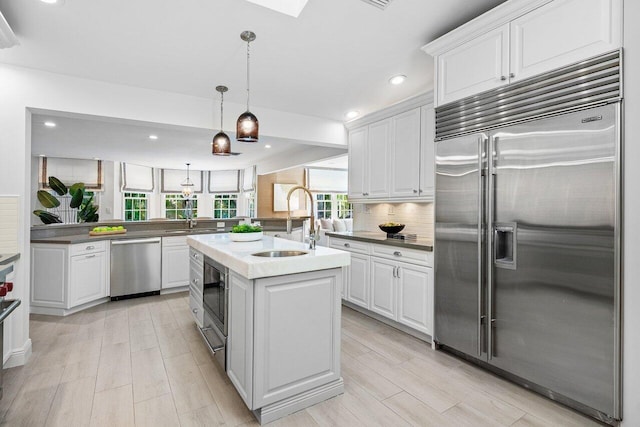 3356 NW 24th Way, Boca Raton, FL 33431 - kitchen featuring built in appliances, an island with sink, white cabinets, decorative backsplash, and recessed lighting