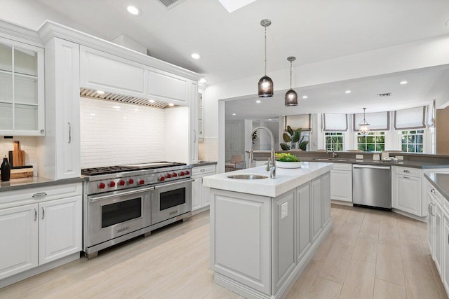 3356 NW 24th Way, Boca Raton, FL 33431 - kitchen featuring stainless steel appliances, decorative backsplash, a center island with sink, white cabinets, and recessed lighting