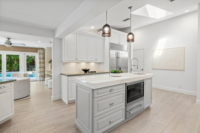 3356 NW 24th Way, Boca Raton, FL 33431 - kitchen with built in appliances, a skylight, decorative backsplash, white cabinets, and recessed lighting