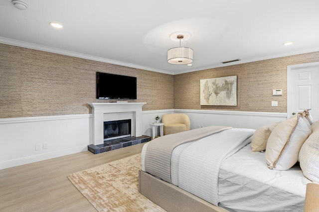 3356 NW 24th Way, Boca Raton, FL 33431 - bedroom with wainscoting, a tile fireplace, wood finished floors, ornamental molding, and wallpapered walls