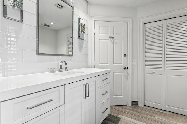 3356 NW 24th Way, Boca Raton, FL 33431 - bathroom featuring vanity, a closet, wood finished floors, and backsplash
