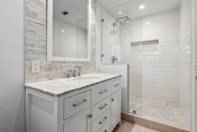 3356 NW 24th Way, Boca Raton, FL 33431 - bathroom featuring tiled shower, vanity, and decorative backsplash