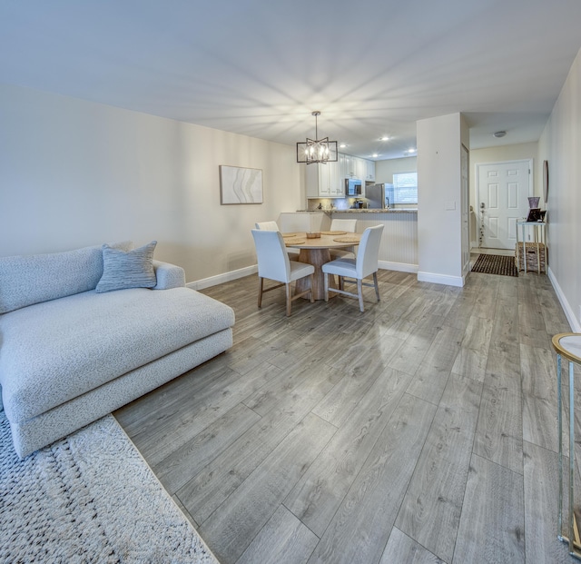 1428 S Lakeside Dr Unit 31, Lake Worth Beach, FL 33460 - dining room featuring a chandelier, light wood-style floors, and baseboards