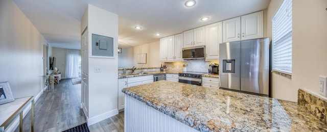 1428 S Lakeside Dr Unit 31, Lake Worth Beach, FL 33460 - kitchen with stainless steel appliances, a peninsula, a sink, white cabinets, and wood finished floors