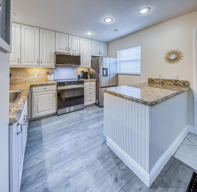 1428 S Lakeside Dr Unit 31, Lake Worth Beach, FL 33460 - kitchen featuring range with electric cooktop, stainless steel fridge with ice dispenser, a peninsula, light wood-style floors, and white cabinets