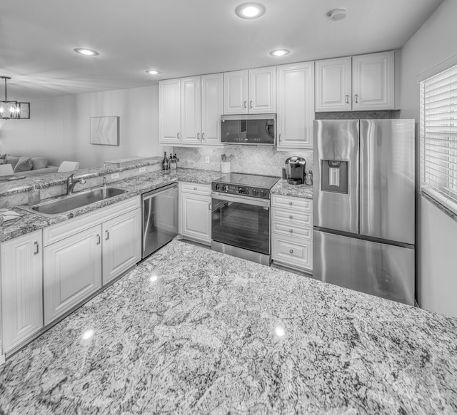 1428 S Lakeside Dr Unit 31, Lake Worth Beach, FL 33460 - kitchen featuring appliances with stainless steel finishes, a sink, light stone countertops, white cabinetry, and recessed lighting