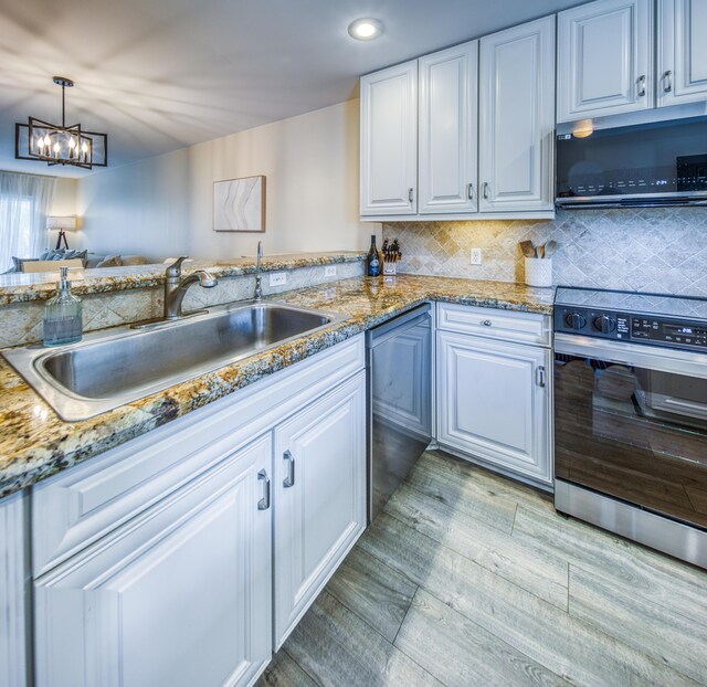 1428 S Lakeside Dr Unit 31, Lake Worth Beach, FL 33460 - kitchen featuring stainless steel appliances, a sink, light wood finished floors, white cabinetry, and a chandelier
