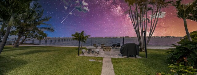 1428 S Lakeside Dr Unit 31, Lake Worth Beach, FL 33460 - yard at dusk featuring a lawn, a water view, and a patio area