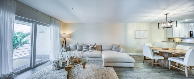 1428 S Lakeside Dr Unit 31, Lake Worth Beach, FL 33460 - living room featuring a chandelier, wood finished floors, and baseboards