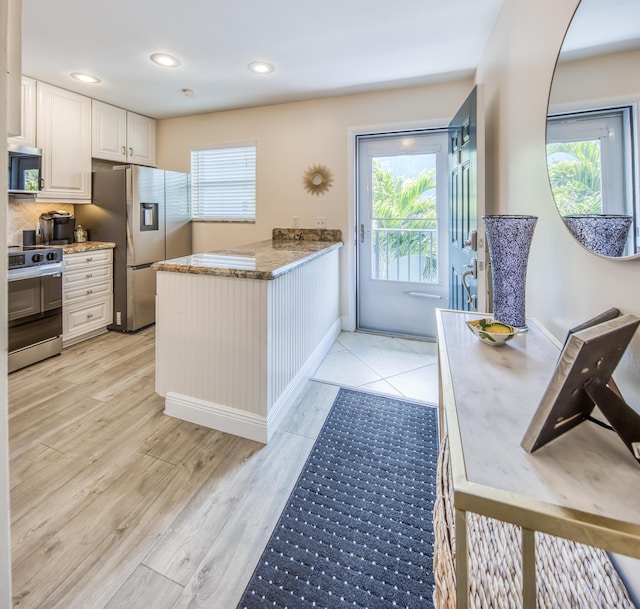 1428 S Lakeside Dr Unit 31, Lake Worth Beach, FL 33460 - kitchen featuring appliances with stainless steel finishes, light stone counters, light wood finished floors, recessed lighting, and white cabinetry