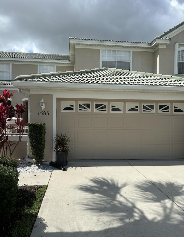 1583 SW Harbour Isles Cir Unit 57, Port Saint Lucie, FL 34986 - view of front of house featuring stucco siding, a tile roof, driveway, and a garage