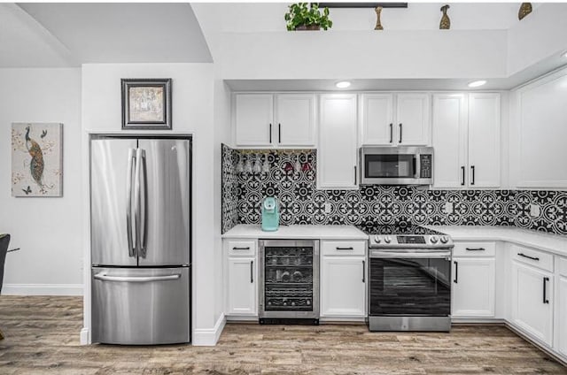 1583 SW Harbour Isles Cir Unit 57, Port Saint Lucie, FL 34986 - kitchen with appliances with stainless steel finishes, beverage cooler, white cabinetry, and light countertops