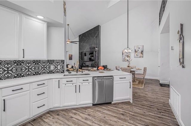 1583 SW Harbour Isles Cir Unit 57, Port Saint Lucie, FL 34986 - kitchen featuring dishwasher, a sink, wood finished floors, white cabinets, and tasteful backsplash