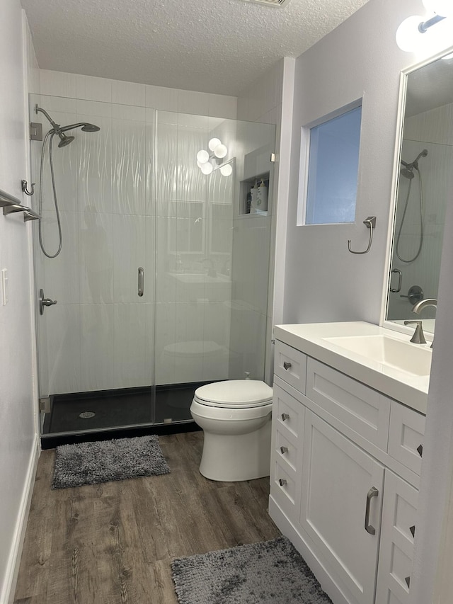 1583 SW Harbour Isles Cir Unit 57, Port Saint Lucie, FL 34986 - full bathroom with wood finished floors, a shower stall, toilet, a textured ceiling, and vanity