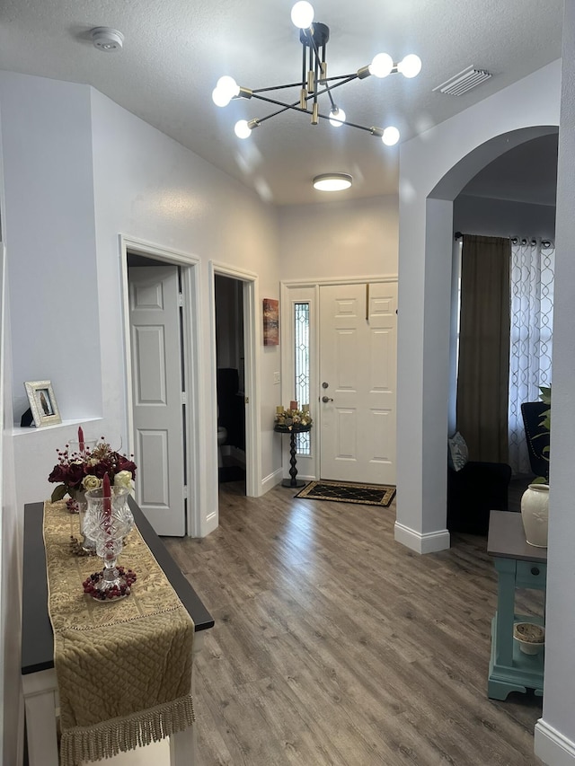 1583 SW Harbour Isles Cir Unit 57, Port Saint Lucie, FL 34986 - foyer entrance with arched walkways, wood finished floors, a chandelier, and baseboards