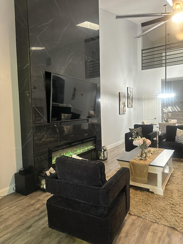 1583 SW Harbour Isles Cir Unit 57, Port Saint Lucie, FL 34986 - living room with a high end fireplace, wood finished floors, a high ceiling, baseboards, and a ceiling fan