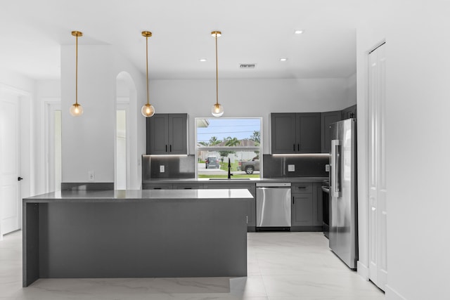 4037 SW Port St Lucie Blvd, Port Saint Lucie, FL 34953 - kitchen with appliances with stainless steel finishes, a sink, a peninsula, arched walkways, and tasteful backsplash