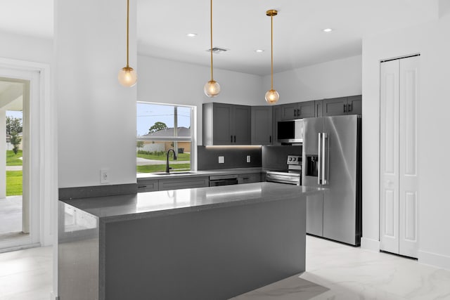 4037 SW Port St Lucie Blvd, Port Saint Lucie, FL 34953 - kitchen featuring stainless steel appliances, a sink, gray cabinets, a peninsula, and hanging light fixtures