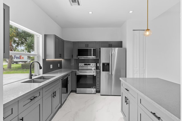 4037 SW Port St Lucie Blvd, Port Saint Lucie, FL 34953 - kitchen featuring appliances with stainless steel finishes, a sink, light marble finish flooring, gray cabinetry, and backsplash
