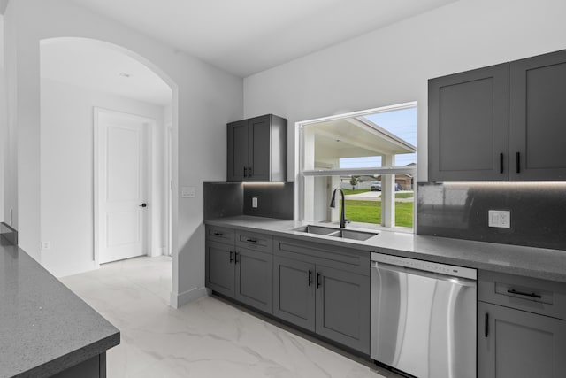 4037 SW Port St Lucie Blvd, Port Saint Lucie, FL 34953 - kitchen featuring stainless steel dishwasher, a sink, arched walkways, light marble finish flooring, and gray cabinetry