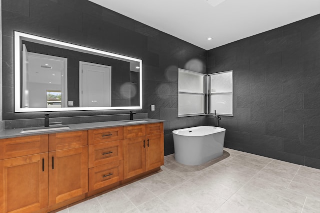 4037 SW Port St Lucie Blvd, Port Saint Lucie, FL 34953 - bathroom featuring tile walls, double vanity, a freestanding tub, and tile patterned flooring