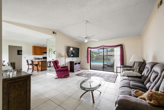 858 SE Roulette Ln, Port Saint Lucie, FL 34983 - living area featuring light tile patterned flooring, lofted ceiling, a ceiling fan, and a textured ceiling