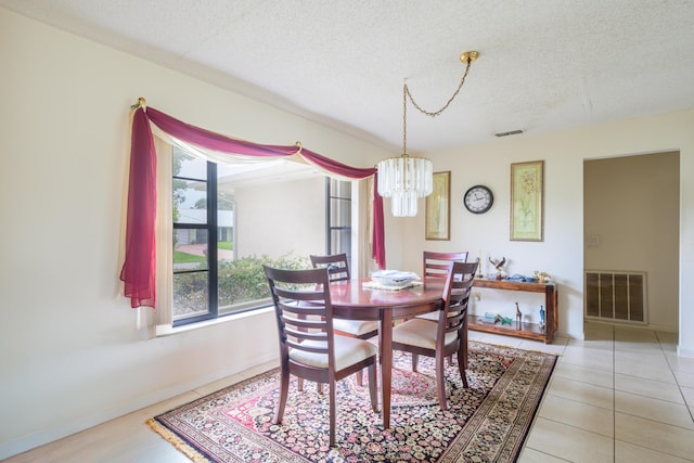 858 SE Roulette Ln, Port Saint Lucie, FL 34983 - dining room featuring a chandelier, a textured ceiling, baseboards, and light tile patterned flooring