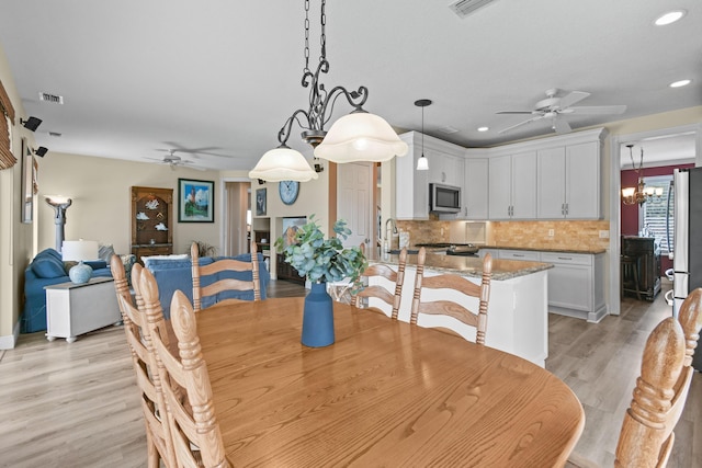 256 Coconut Pt, Jupiter, FL 33458 - dining room featuring ceiling fan, light wood-style floors, recessed lighting, and a chandelier