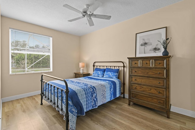 256 Coconut Pt, Jupiter, FL 33458 - bedroom with light wood-style floors, baseboards, a textured ceiling, and a ceiling fan
