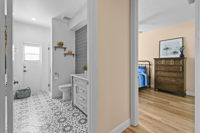 256 Coconut Pt, Jupiter, FL 33458 - ensuite bathroom featuring a textured ceiling, vanity, toilet, baseboards, and a shower