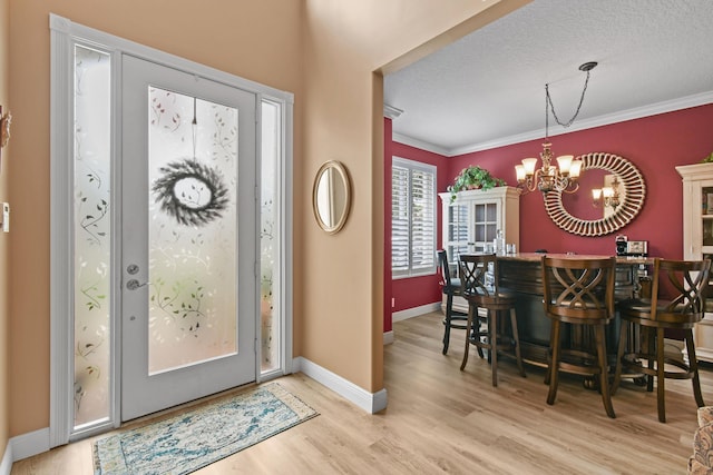 256 Coconut Pt, Jupiter, FL 33458 - entrance foyer featuring ornamental molding, light wood finished floors, a chandelier, baseboards, and a textured ceiling