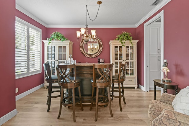256 Coconut Pt, Jupiter, FL 33458 - dining area featuring a chandelier, a dry bar, light wood finished floors, baseboards, and crown molding