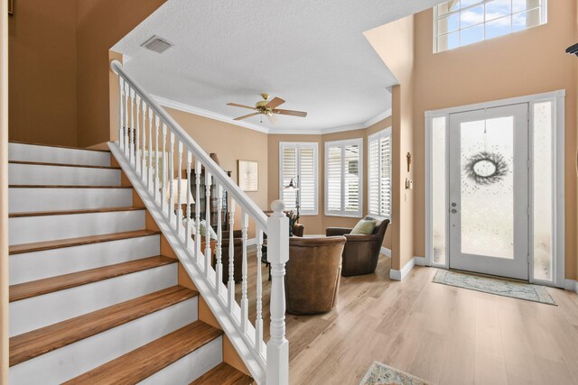 256 Coconut Pt, Jupiter, FL 33458 - entryway featuring a ceiling fan, crown molding, healthy amount of natural light, wood finished floors, and stairs