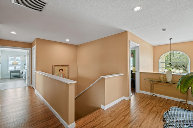 256 Coconut Pt, Jupiter, FL 33458 - hallway with an upstairs landing, plenty of natural light, wood finished floors, a textured ceiling, and recessed lighting