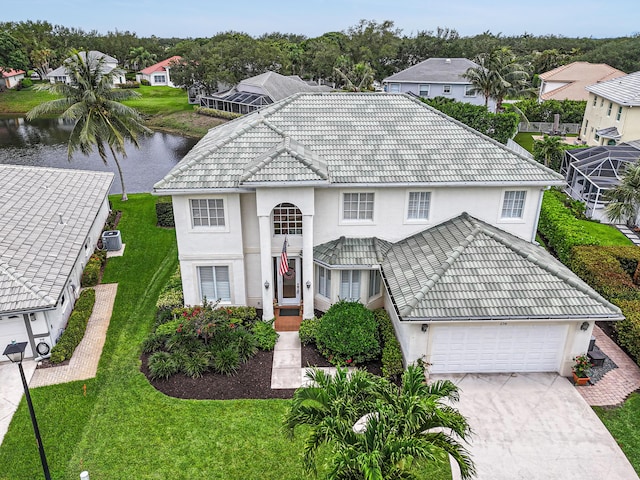 256 Coconut Pt, Jupiter, FL 33458 - view of front facade featuring a tiled roof, stucco siding, a water view, concrete driveway, and a garage