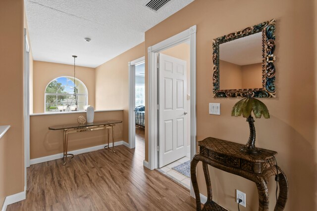 256 Coconut Pt, Jupiter, FL 33458 - foyer entrance with wood finished floors, healthy amount of natural light, baseboards, and a textured ceiling