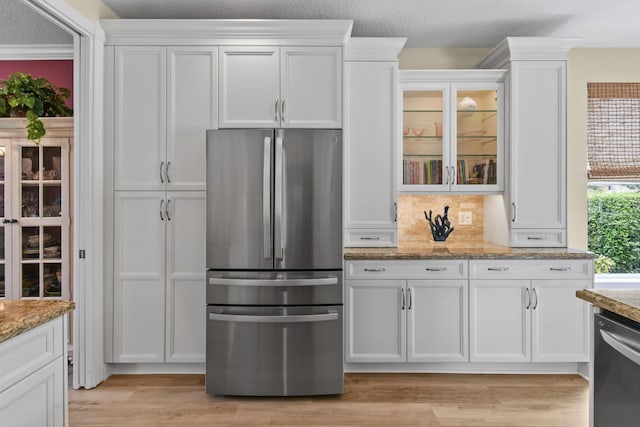 256 Coconut Pt, Jupiter, FL 33458 - kitchen with appliances with stainless steel finishes, white cabinetry, light stone countertops, and glass insert cabinets