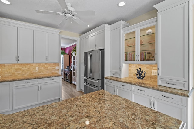 256 Coconut Pt, Jupiter, FL 33458 - kitchen featuring freestanding refrigerator, white cabinets, wood finished floors, decorative backsplash, and glass insert cabinets