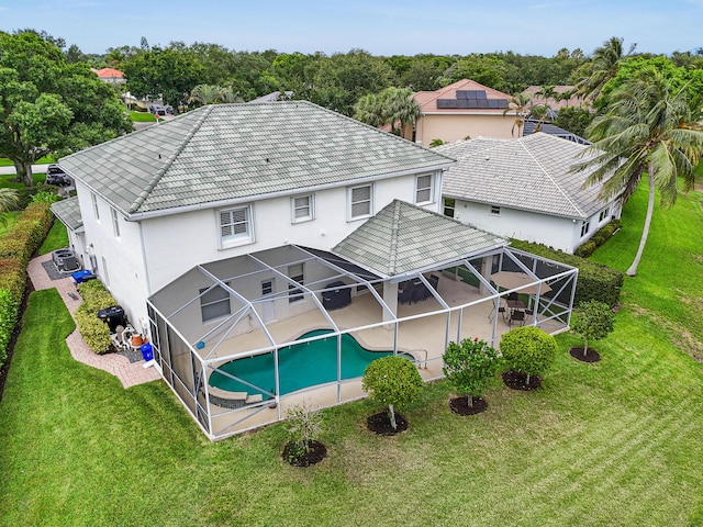 256 Coconut Pt, Jupiter, FL 33458 - rear view of house featuring a patio, glass enclosure, an outdoor pool, and a yard