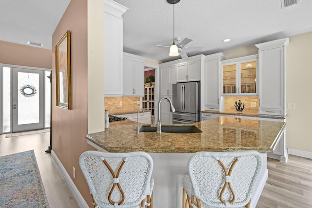 256 Coconut Pt, Jupiter, FL 33458 - kitchen with freestanding refrigerator, a sink, a peninsula, stone countertops, and baseboards