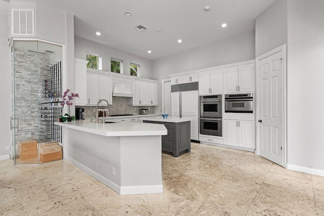 16370 Via Fontana, Delray Beach, FL 33484 - kitchen with stainless steel double oven, a sink, light countertops, custom range hood, and decorative backsplash